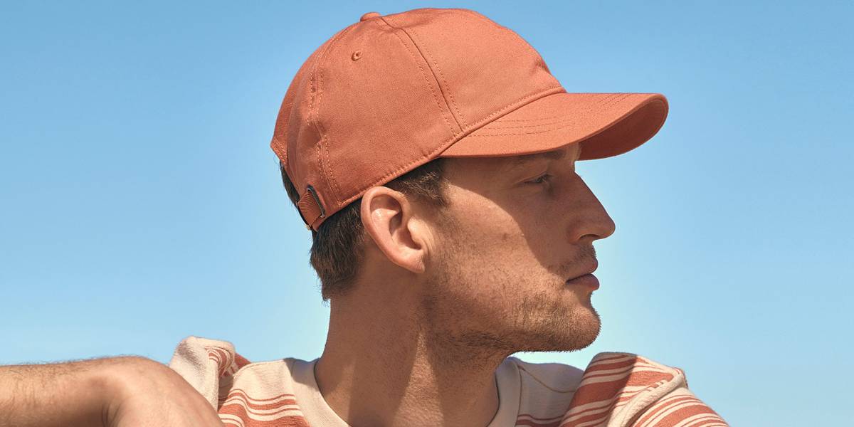 Model wearing an orange baseball cap